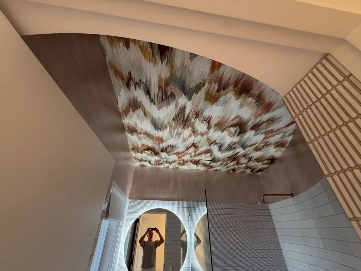 EBRU Black Edition wallpaper on a bathroom ceiling above a backlit round mirror