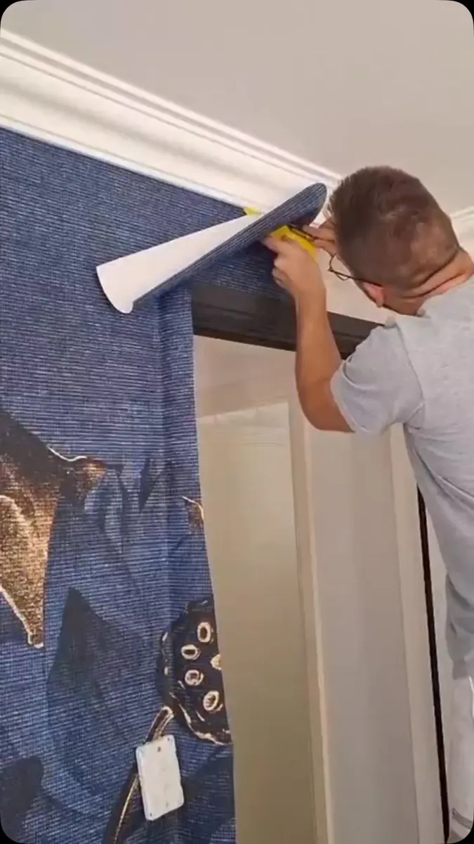 Lotus Indigo wallpaper being trimmed at the cornice